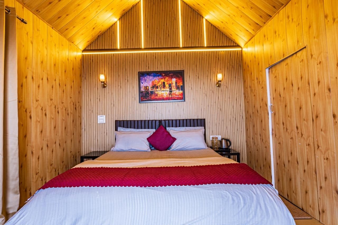 Warm wood-panelled bedroom at Spandan Villas with king bed and red accent throw