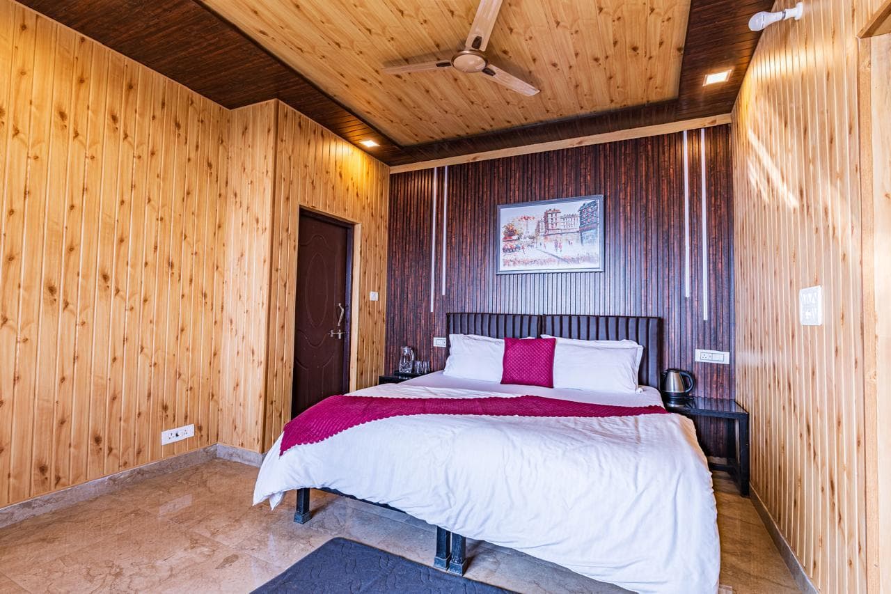 Spacious cedar-lined bedroom at Spandan Villas with warm timber walls and king bed